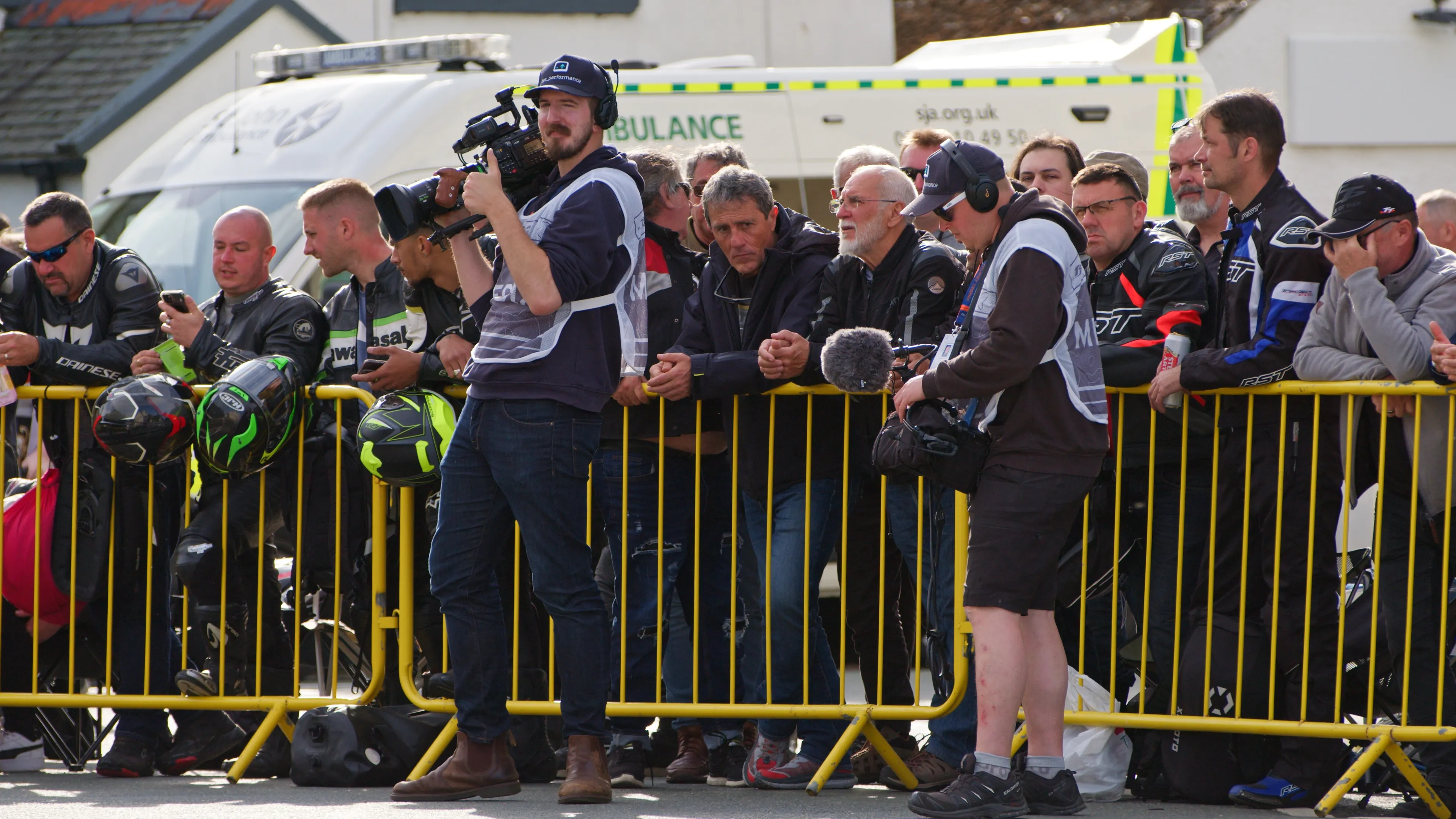 Will Oates filming at the Isle of Man TT races with The URSA 12K Cinema Camera while Juan Readshaw records sound, both wearing white TT-accredited tabards on the Isle of Man course